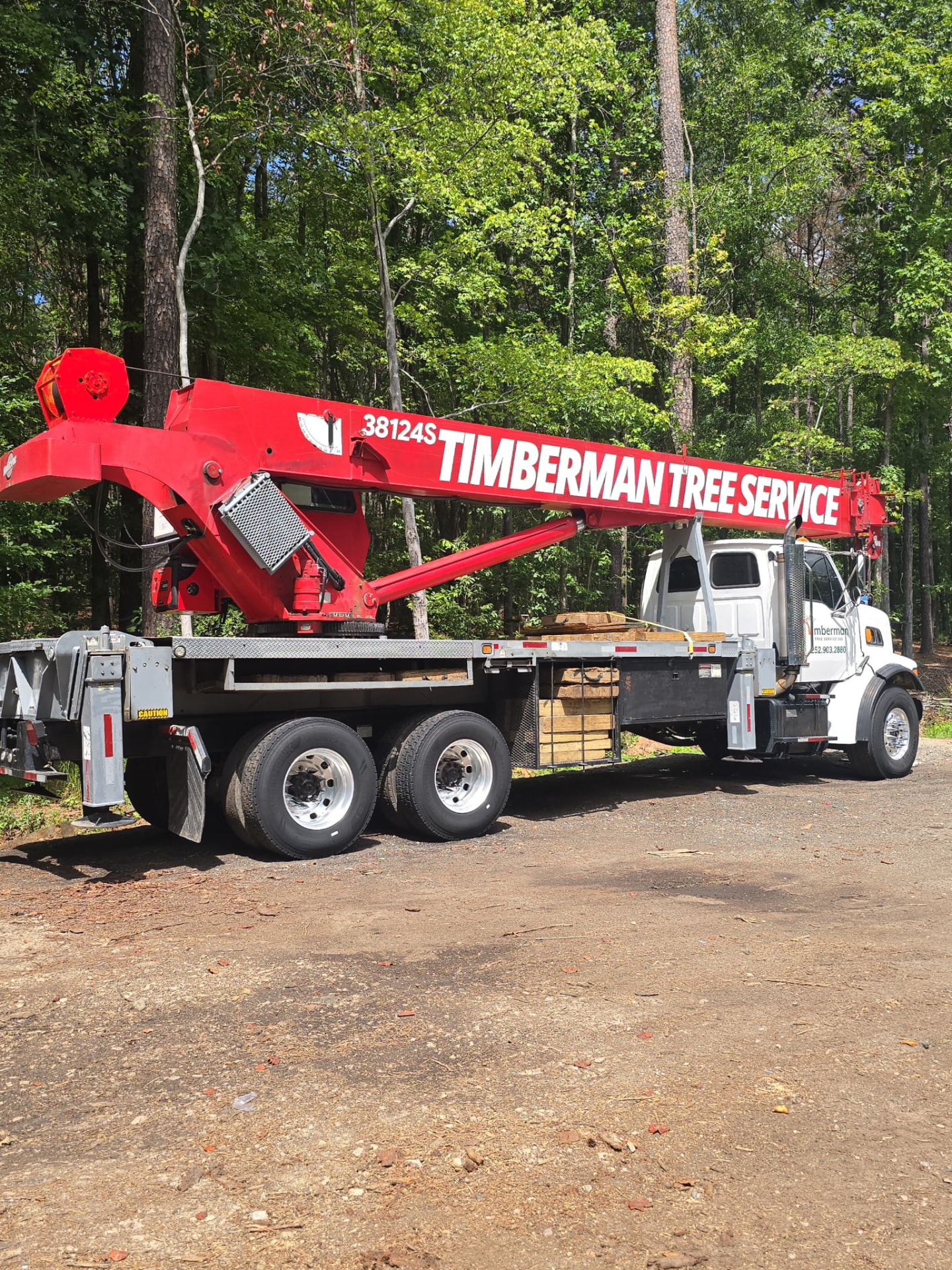 Timberman Tree Service crane truck with company lettering on the boom in Raleigh, NC